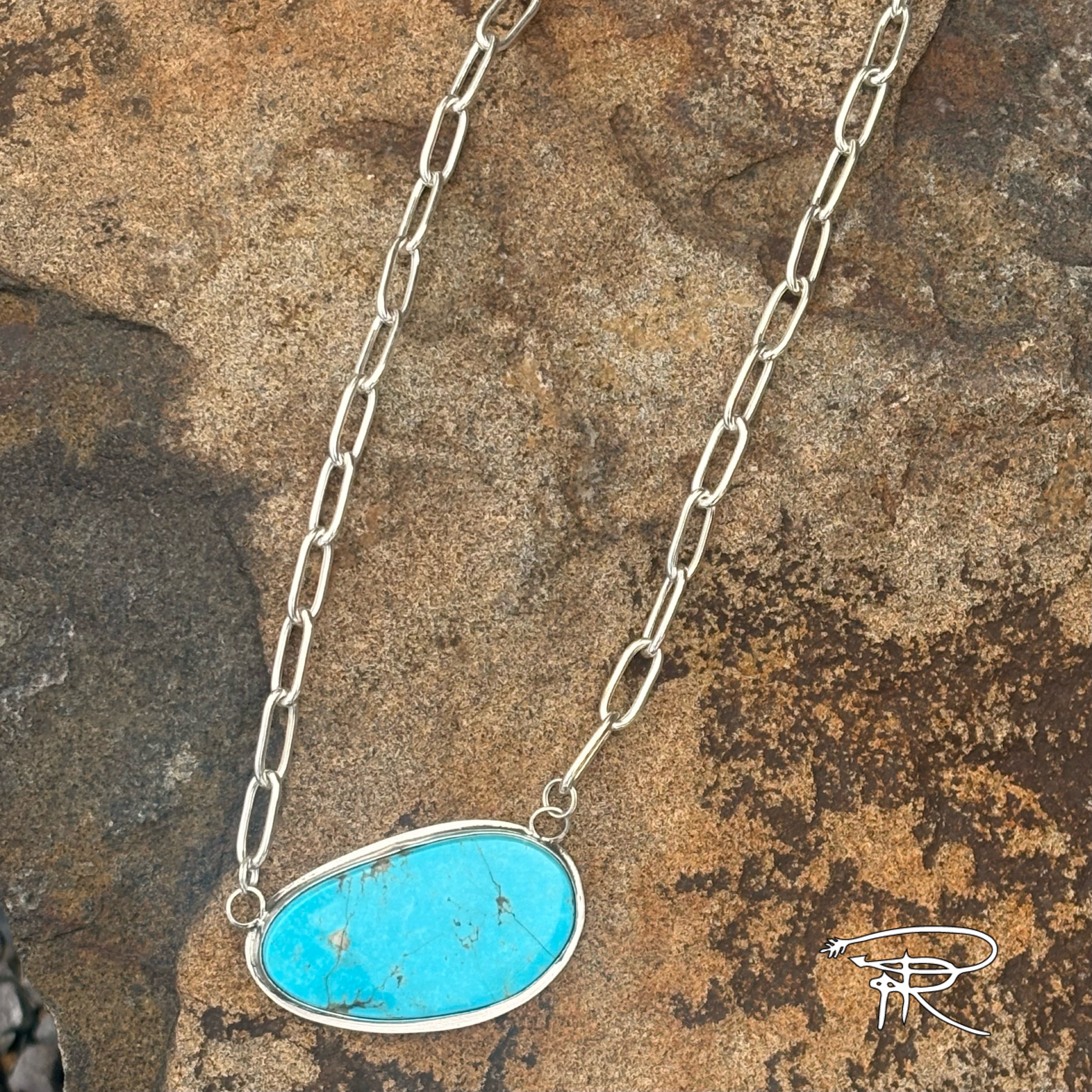 Turquoise pendant necklace on a stone background