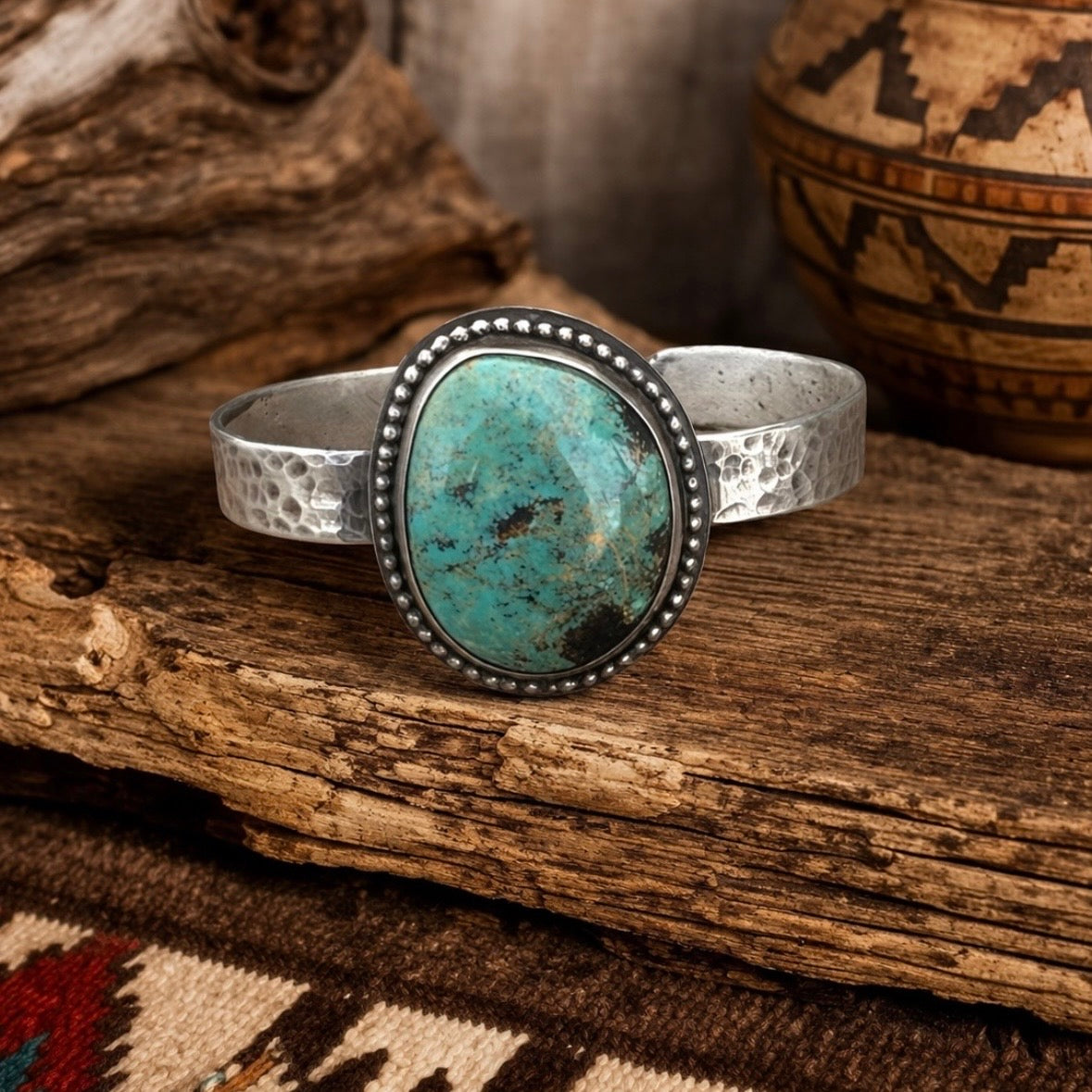 Silver bracelet with a turquoise stone on a wooden surface